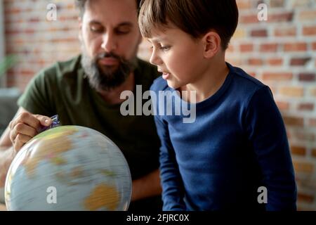 Son and father looking at spinning globe Stock Photo