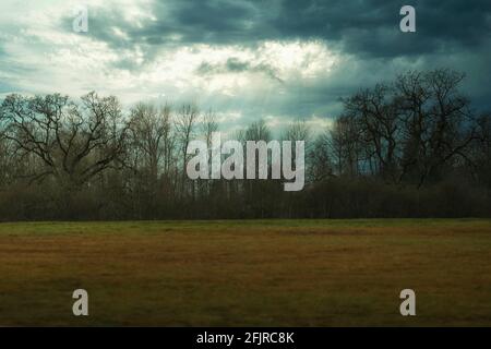 dramatic early morning sunlight streaming through patchy clouds Stock Photo