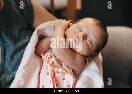 Close up photo of a caucasian kid napping while his mother is holding him Stock Photo