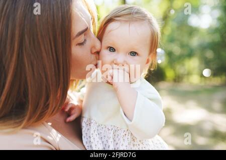 happy harmonious family outdoors. mother kissing her baby, playing in the summer on the nature Stock Photo