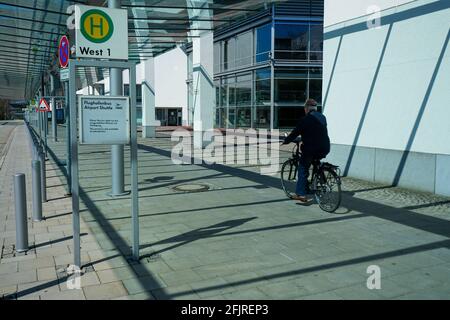 A man rides his bicycle past a bus stop at the Internationales Congress Center München. Stock Photo