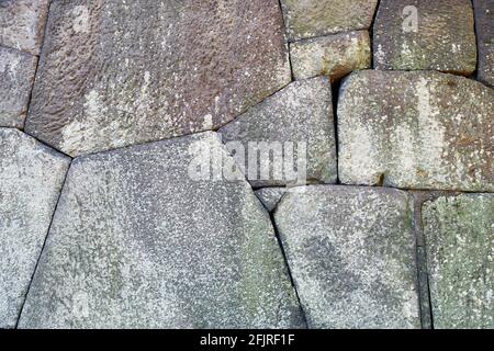 Background of old Edo castle polygonal masonry made in Burdock piling technique  used to build sloped stone walls. Tokyo Imperial Palace. Tokyo. Japan Stock Photo