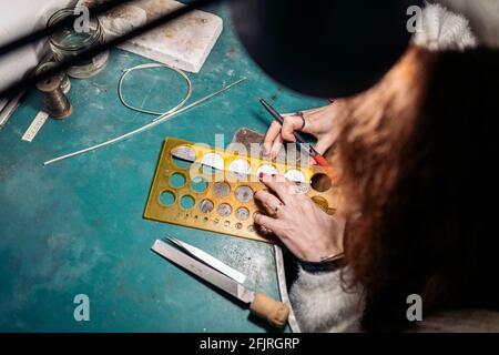 Stock photo of faceless woman working in jewelry workshop. Stock Photo