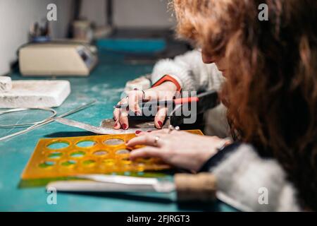 Stock photo of faceless woman working in jewelry workshop. Stock Photo