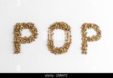 Top view on lettering POP made from golden nuggets on white background Stock Photo