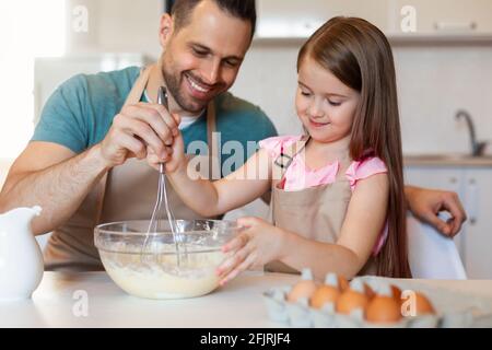 Cheerful Father And Daughter Cooking Pancakes Making Dough In Kitchen Stock Photo