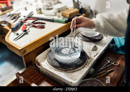 Faceless craftswoman working in jewelry workshop. Stock Photo