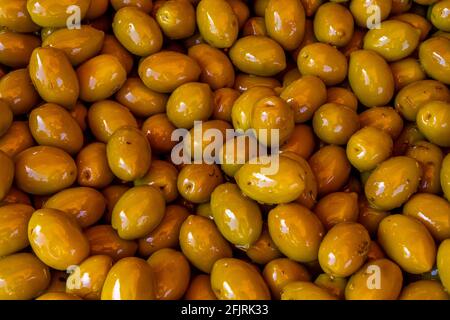 Green pickled Olives at the weekly market in french province. Background of olives in a bowl, close up.  Stock Photo