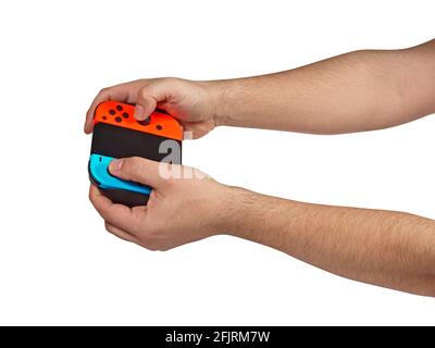 Video game console controller in gamer hands playing videogame.Game controller in hand isolated on white background. Stock Photo