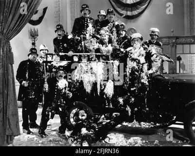 KEYSTONE KOPS including FORD STERLING and BOBBY DUNN on set candid portrait covered in Custard Pies taken during filming of the slapstick comedy short KEYSTONE HOTEL 1935 director RALPH STAUB story and screenplay Joe Traub The Vitaphone Corporation / Warner Bros. Stock Photo