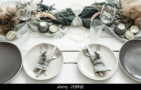 Stylish festive table setting with Scandinavian decor details on a wooden surface. Stock Photo