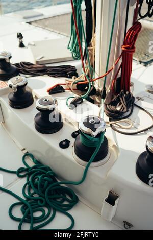 White mast of a sailing yacht with winch halyards and colorful cables Stock Photo