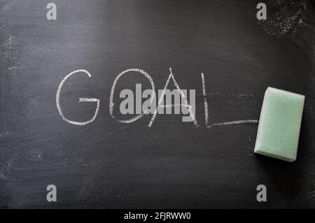 erasing goal, hand written word on blackboard being erased concept Stock Photo