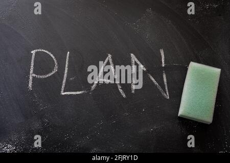 erasing plan, hand written word on blackboard being erased concept Stock Photo