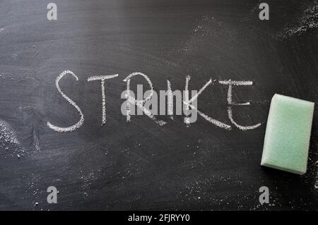 erasing strike, hand written word on blackboard being erased concept Stock Photo