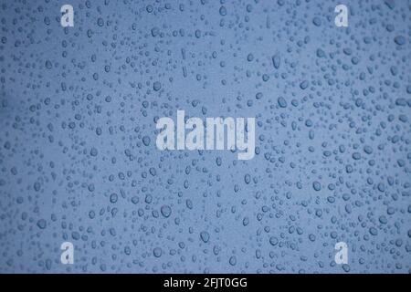 Blue abstract sky and raindrops on glass window Stock Photo