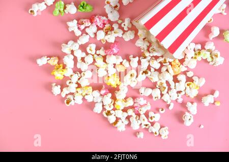 popcorn spilling from a container on pink background  Stock Photo