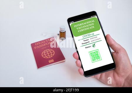 Smartphone with valid digital vaccination certificate COVID-19.Inmunity passport, health and surveillance concepts. Fake data on screen Stock Photo