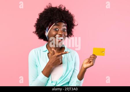 Excited Lady Pointing Finger At Credit Card Over Pink Background Stock Photo