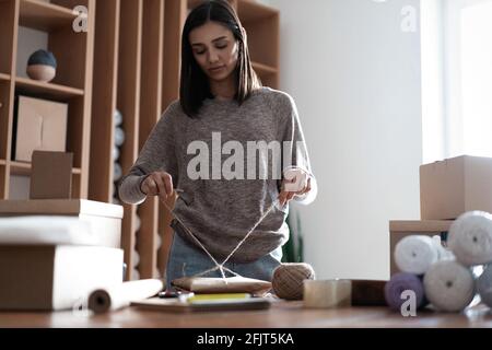 Indian mixed-race female seller using tablet checking ecommerce clothing store orders Stock Photo