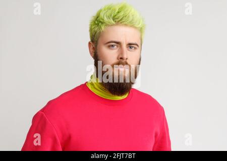 Portrait of handsome Caucasian bearded man, looks directly at camera, has strict and serious facial expression, dresses casual clothing. Indoor studio Stock Photo