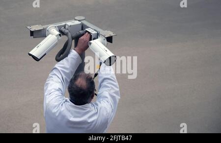A specialist technician is installing video surveillance cameras Stock Photo