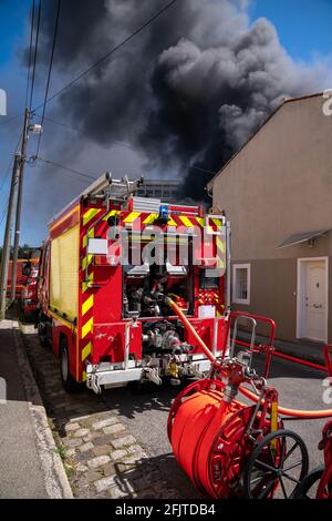 Red Firefighter engine and firefighter putting out huge fire Stock Photo