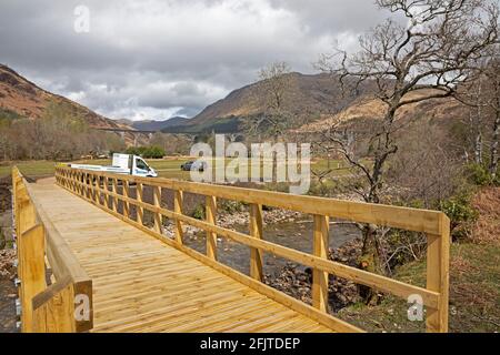 Glenfinnan, Lochaber, UK. 26th April 2021. Jacobite Steam Train first trip of 2021 did not encourage very many  visitors to the newly built car park that leads to the new 'Glenfinnan Wee Harry Potter Bridge' which has been crowdfunded by the  community who raised £8,467 to allow them to build a bridge to cross the River Finnan to keep the normal 350,000 tourists  that arrive each year safe and off of the busy road that runs between Fort William and Mallaig. Stock Photo