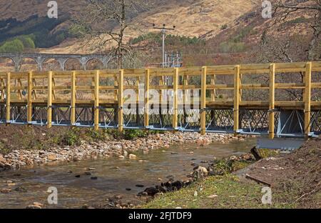 Glenfinnan, Lochaber, UK. 26th April 2021. Jacobite Steam Train first trip of 2021 did not encourage very many  visitors to the newly built car park that leads to the new 'Glenfinnan Wee Harry Potter Bridge' which has been crowdfunded by the  community who raised £8,467 to allow them to build a bridge to cross the River Finnan to keep the normal 350,000 tourists  that arrive each year safe and off of the busy road that runs between Fort William and Mallaig. Stock Photo