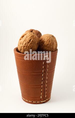walnuts in a leather glass on a white background Stock Photo