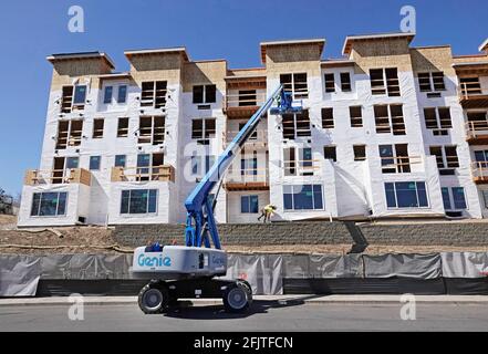 Construction workers put the final touches on a massive apartment complex being built along the Deschutes River in Bend, Oregon. Bend has undergone a Stock Photo