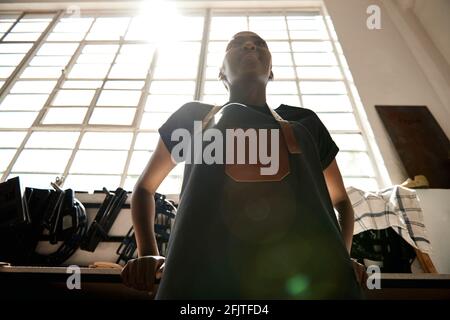 Young African female leather worker standing in her workshop Stock Photo