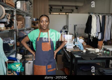 Young African female leather worker standing in her workshop Stock Photo
