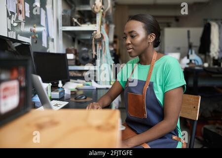 Young African female artisan using a laptop in her workshop Stock Photo