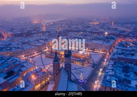 Main square Rynek of the Old Town of Krakow Poland in winter aerial view. St. Mary's Basilica Gothic church and Krakow Cloth Hall, covered in snow at Stock Photo