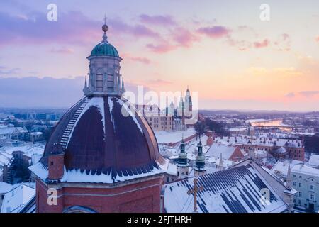 Winter in Krakow Poland aerial view. Saints Peter and Paul Church dome, St. Andrew's Church, and Wawel Royal Castle with Vistula river at sunset. Stock Photo