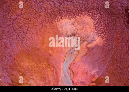 Aerial drone view of industrial chemicals dump site from ironlworks, dry red soil with animal paw prints, unique texture. Stock Photo