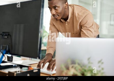 African businessman working on a computer keyboard at his desk Stock Photo