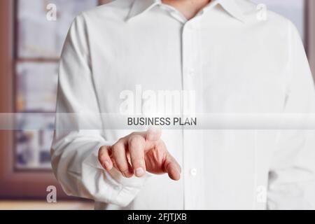 Male hand presses business plan button on a virtual touch screen. Stock Photo