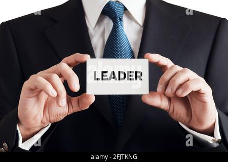 Businessman shows business card with the word leader. Business team or project leadership concept. Stock Photo