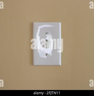 A Light Reflection on a White Switch Plate Stock Photo