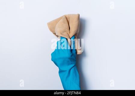 Hand in glove holding microfiber cleaning cloth on white background. Copy space. Cleaning service concept. Spring general or regular clean up Stock Photo