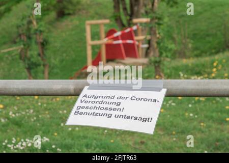 Corona virus quarantine lockdown prohibit playground slide. Covid-19 safety prevention. Closure prohibition sign. German text mean closed because of c Stock Photo