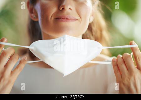covid-19 pandemic. Closeup on middle aged woman taking off ffp2 mask. Stock Photo