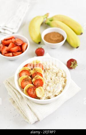 Oatmeal porridge with strawberry and  banana in bowl Stock Photo