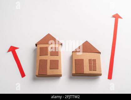 3d paper houses and red arrows pointing up on white background Stock Photo