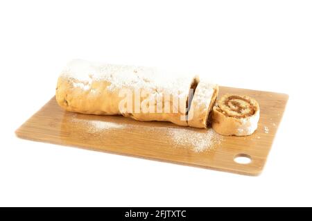 Sliced apple strudel on a wooden cutting board over white background. Copy space. Stock Photo