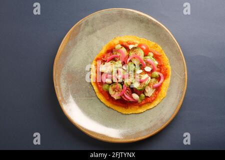 A STILL LIFE OF BRUSSEL SPROUT TACOS,WITH BRUSSEL SPROUTS, CHARRED AND RAW TOMATOES, PICKLED ONIONS, ADOBO SAUCE, SALSA VERDE, PEANUTS,  ON A CORN TOR Stock Photo