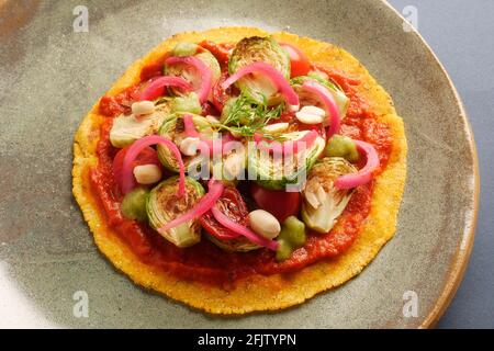 A STILL LIFE OF BRUSSEL SPROUT TACOS,WITH BRUSSEL SPROUTS, CHARRED AND RAW TOMATOES, PICKLED ONIONS, ADOBO SAUCE, SALSA VERDE, PEANUTS,  ON A CORN TOR Stock Photo