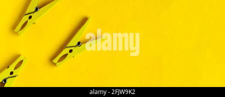 Top view, yellow clothespins on a yellow background, copyspace Stock Photo